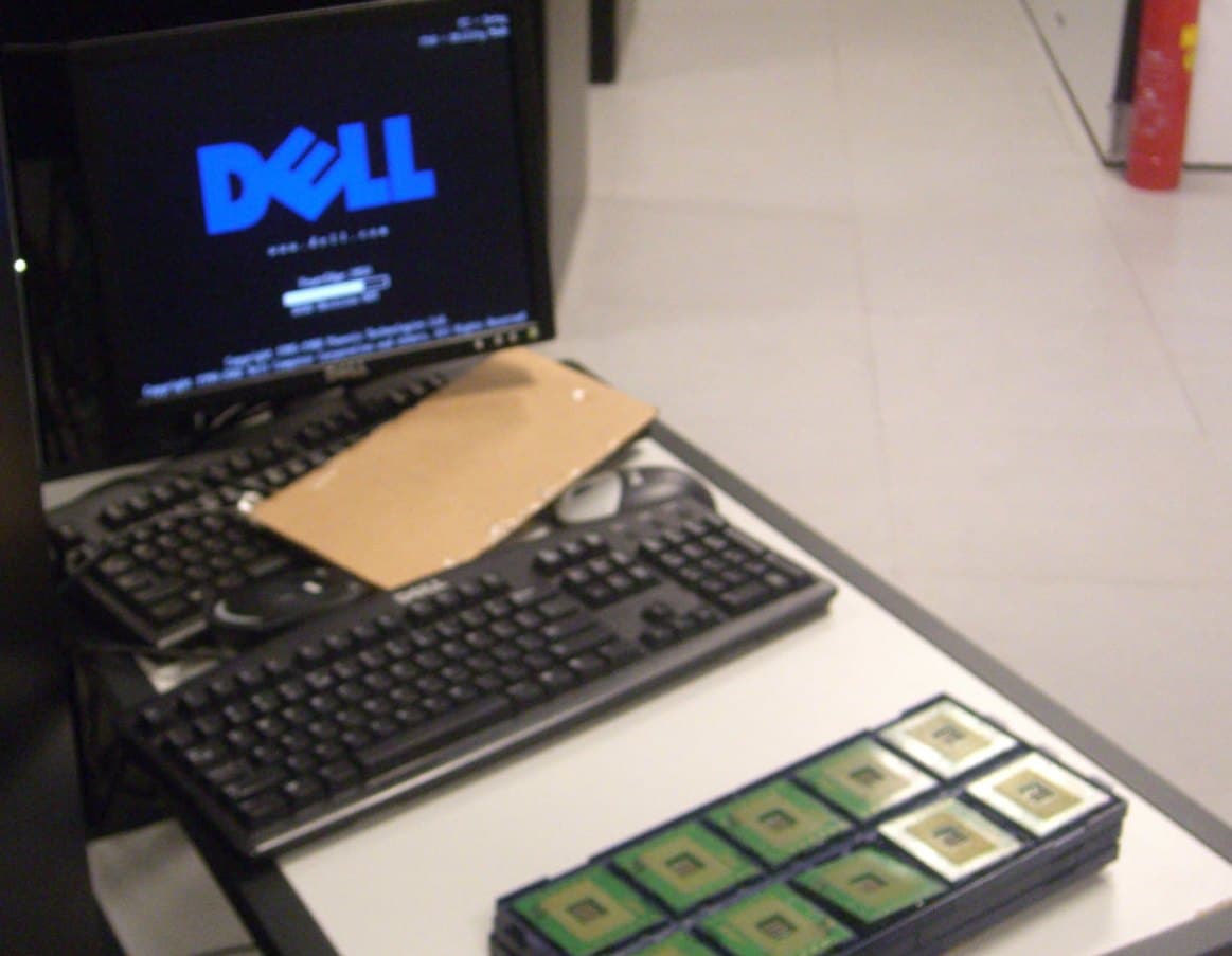 An old console cart in a datacenter aisle: a keyboard propped up on a scrap of cardboard, beside a tray of server processors