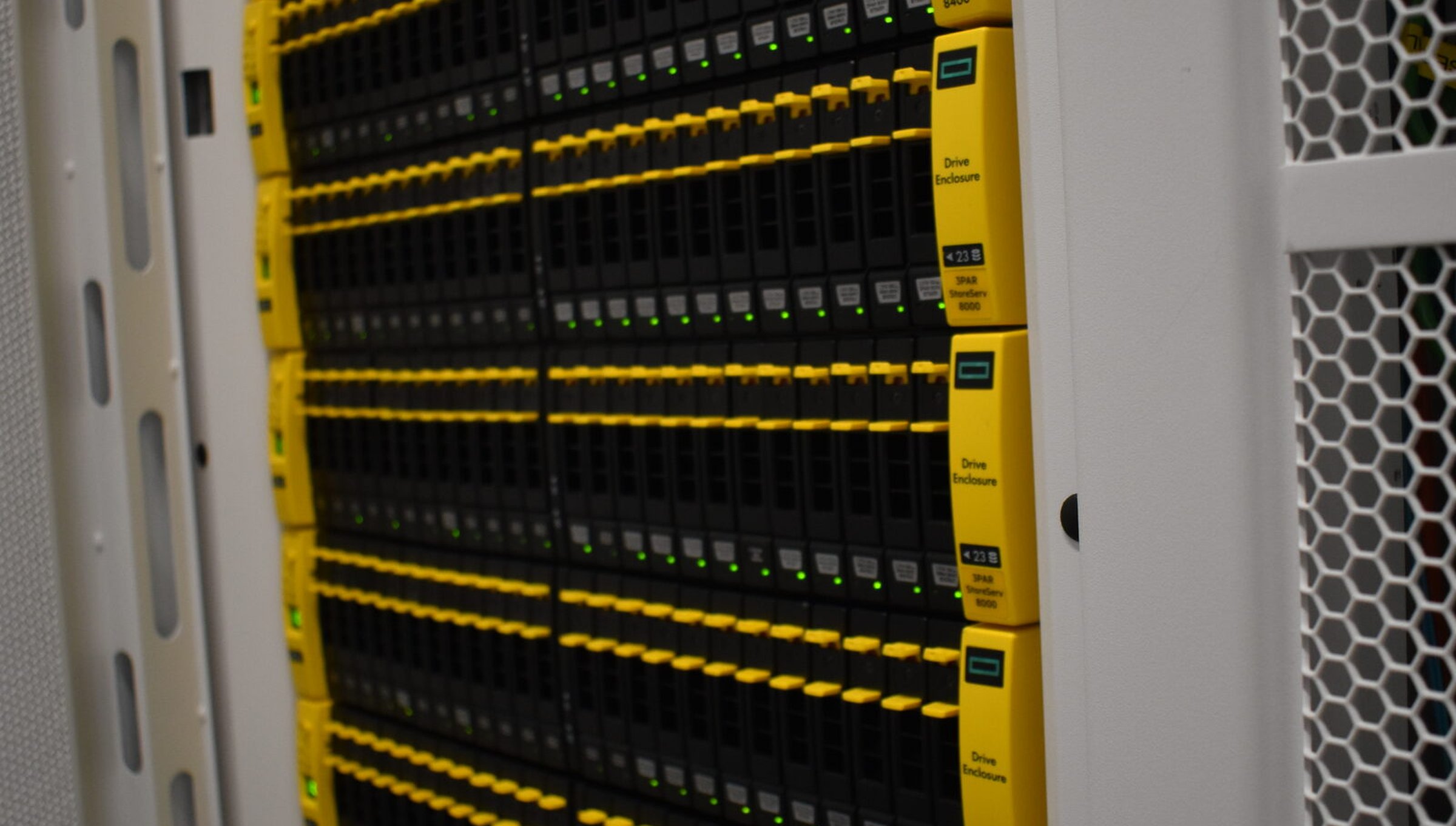A wall of HPE 3PAR arrays in the rack, drive handles lit