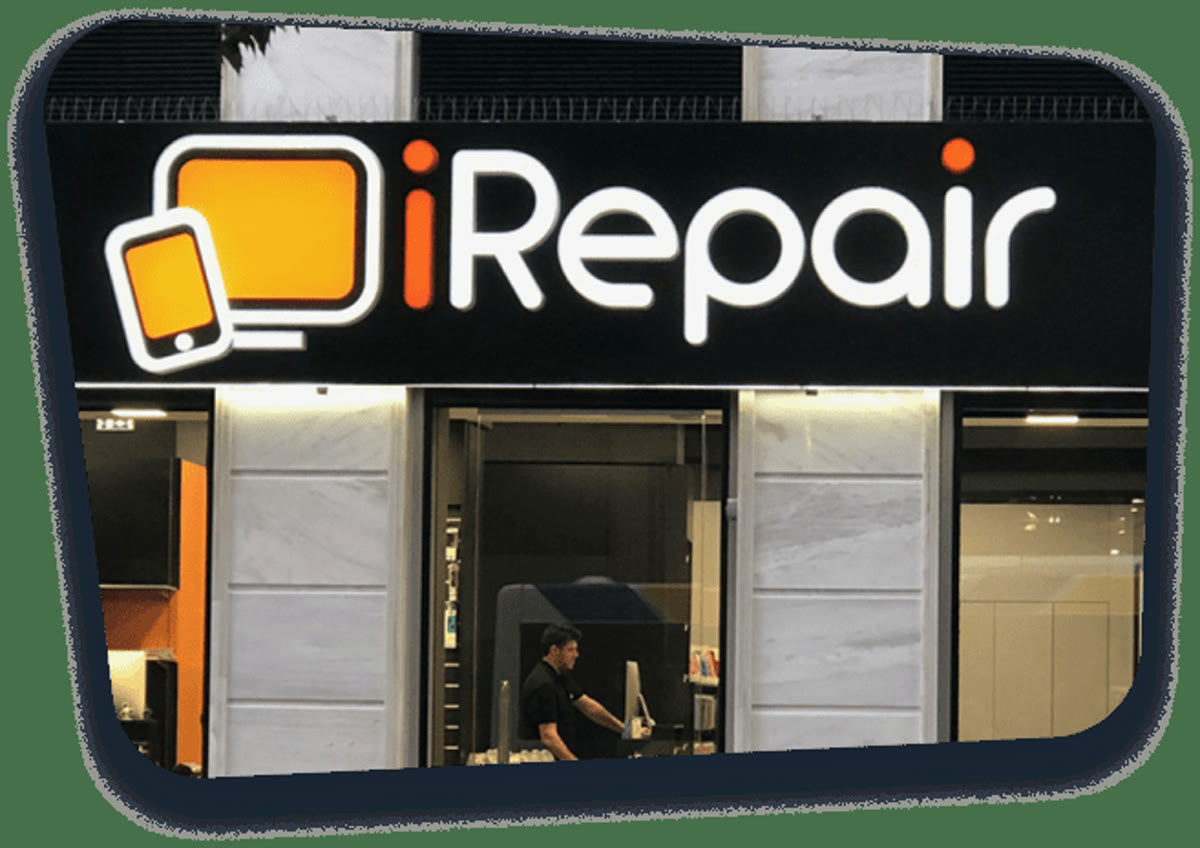 An iRepair storefront at night