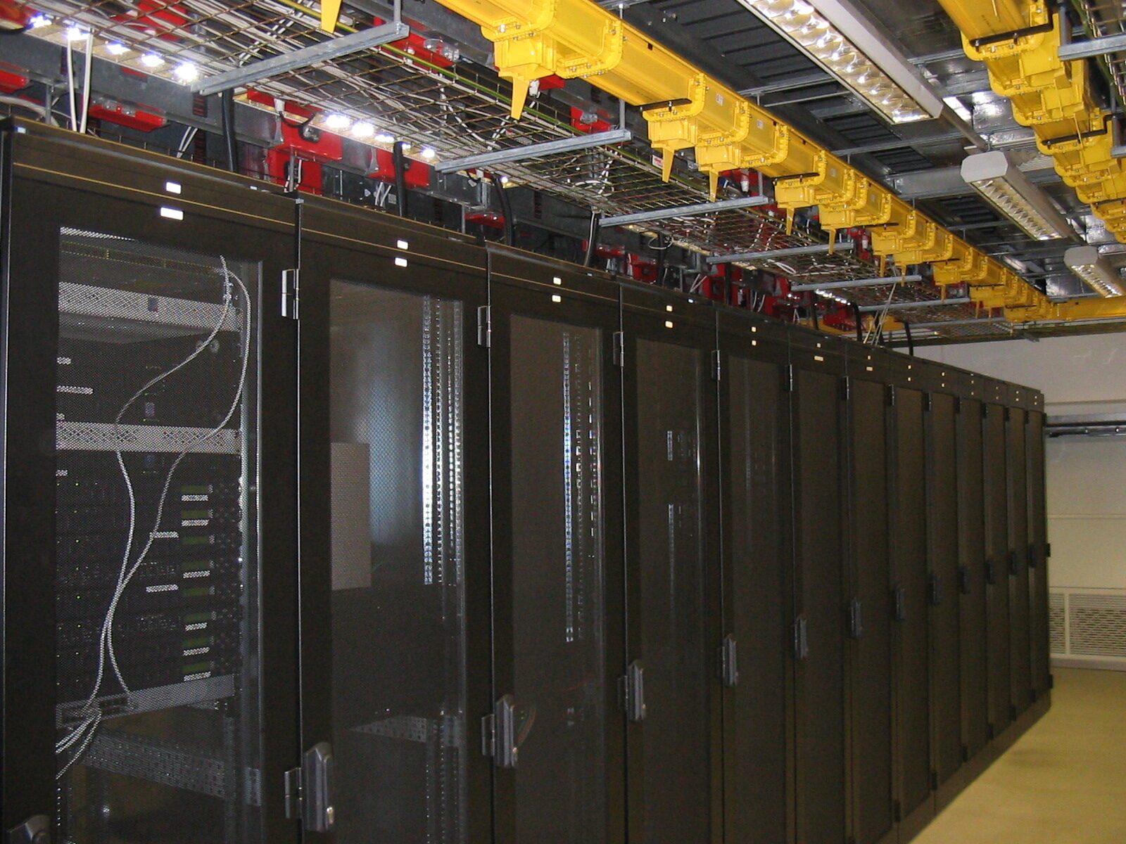 The first hall, Amsterdam, 2004: a row of black cabinets under yellow overhead trays